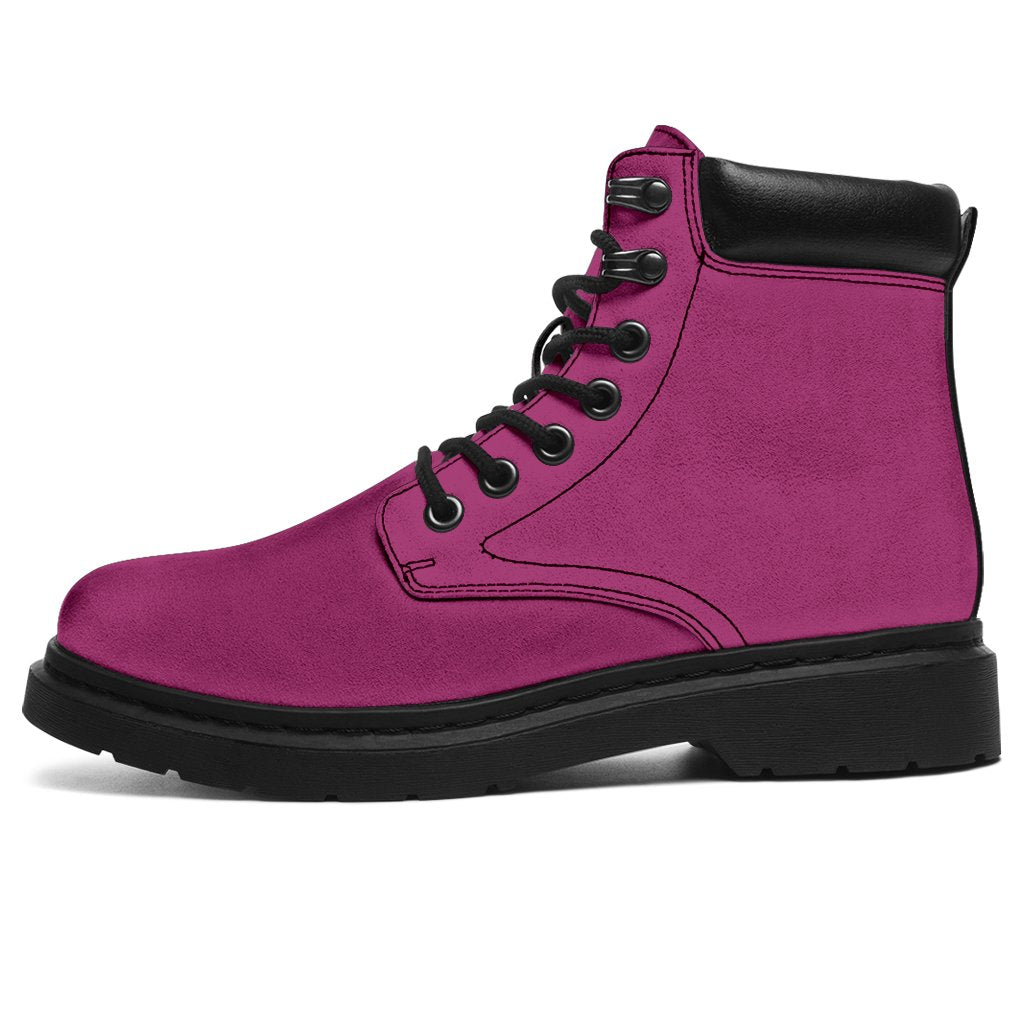 This is a microsuede pair of boots for men and women. It is a magenta pink colour all over. The boot has a black sole black trim, black laces, and sits above the ankle. It is set on a white background.