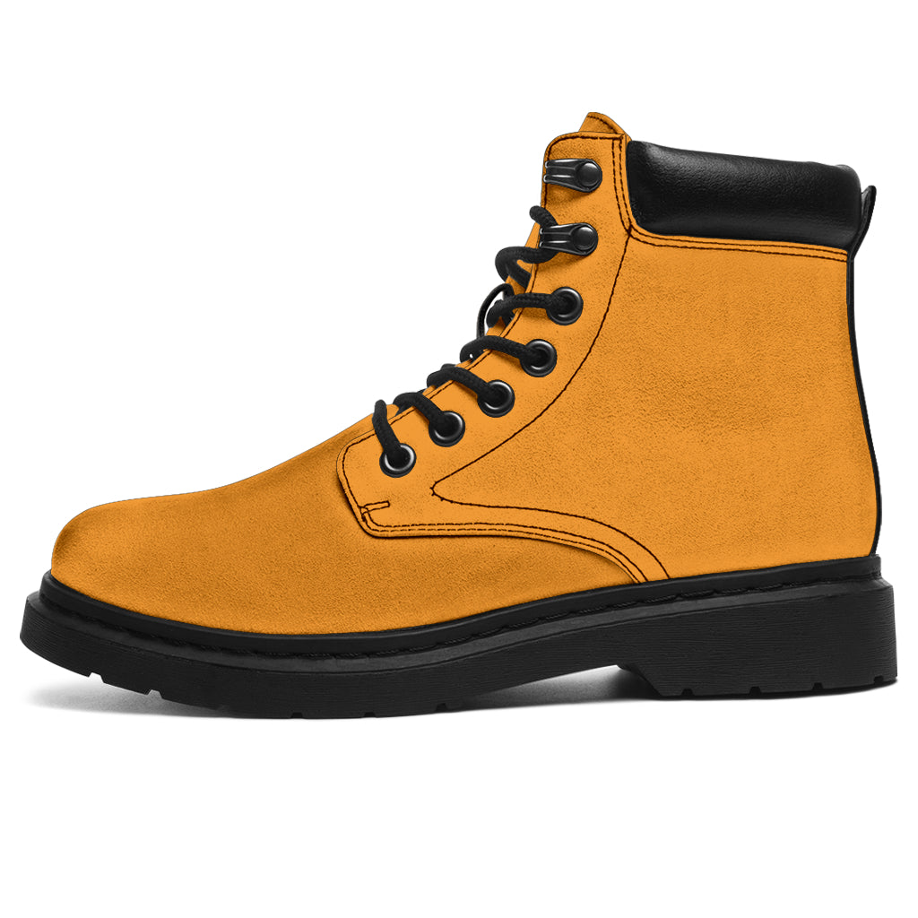 This is a microsuede pair of boots for men and women. It is a mango orange colour all over. The boot has a black sole black trim, black laces, and sits above the ankle. It is set on a white background.