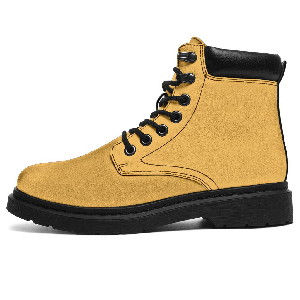 This is a microsuede pair of boots for men and women. It is a dark yellow colour all over. The boot has a black sole black trim, black laces, and sits above the ankle. It is set on a white background.