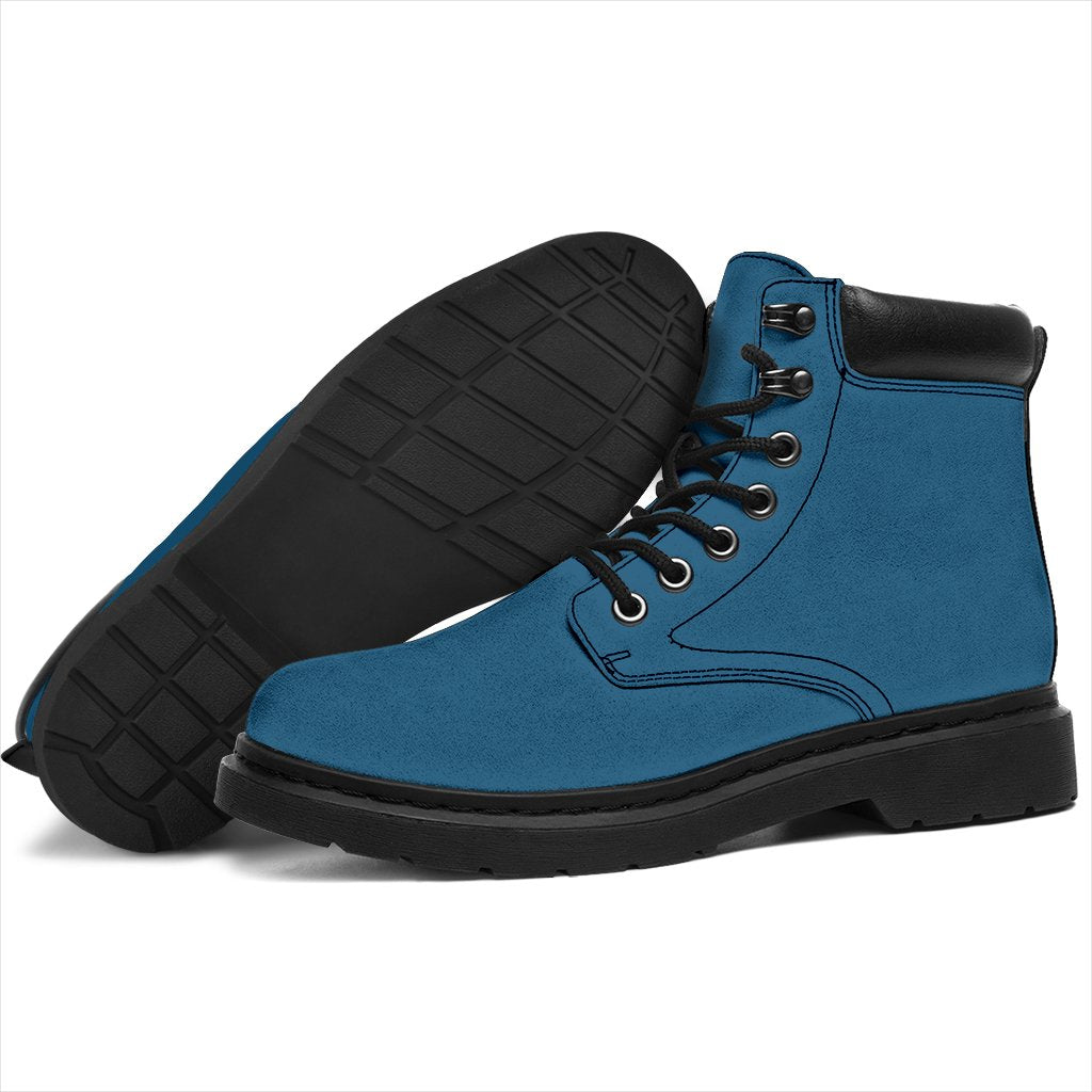 This is a microsuede pair of boots for men and women. It is a vintage sky colour all over. The boot has a black sole black trim, black laces, and sits above the ankle. It is set on a white background.