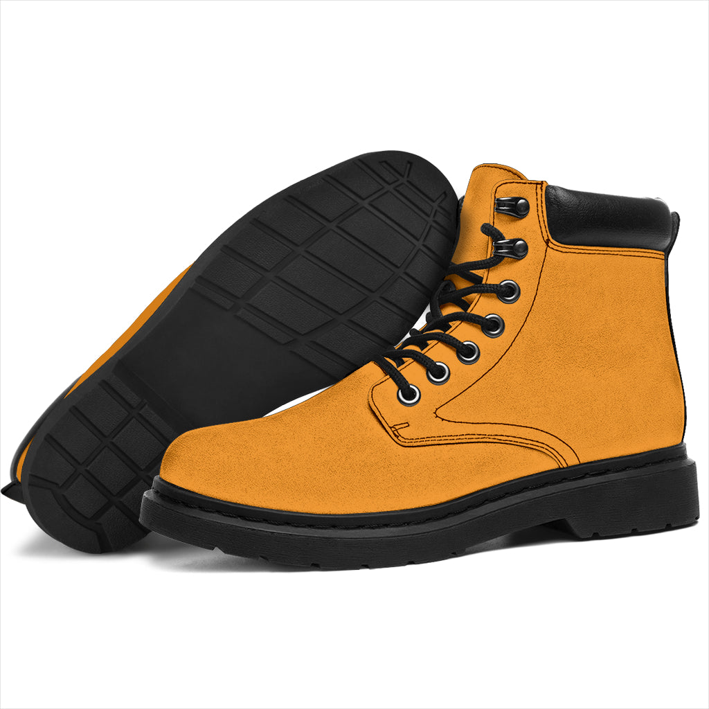 This is a microsuede pair of boots for men and women. It is a mango orange colour all over. The boot has a black sole black trim, black laces, and sits above the ankle. It is set on a white background.