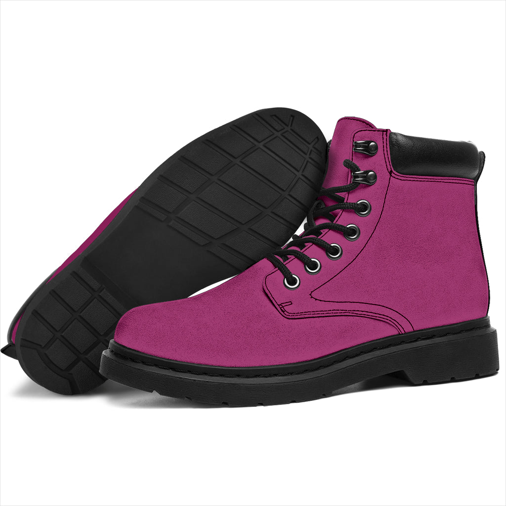 This is a microsuede pair of boots for men and women. It is a magenta pink colour all over. The boot has a black sole black trim, black laces, and sits above the ankle. It is set on a white background.