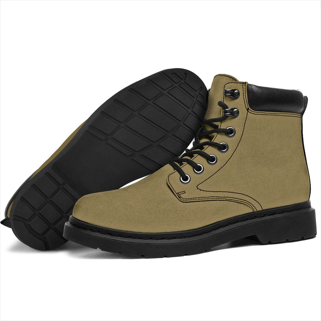 This is a microsuede pair of boots for men and women. It is a light khaki colour all over. The boot has a black sole black trim, black laces, and sits above the ankle. It is set on a white background.