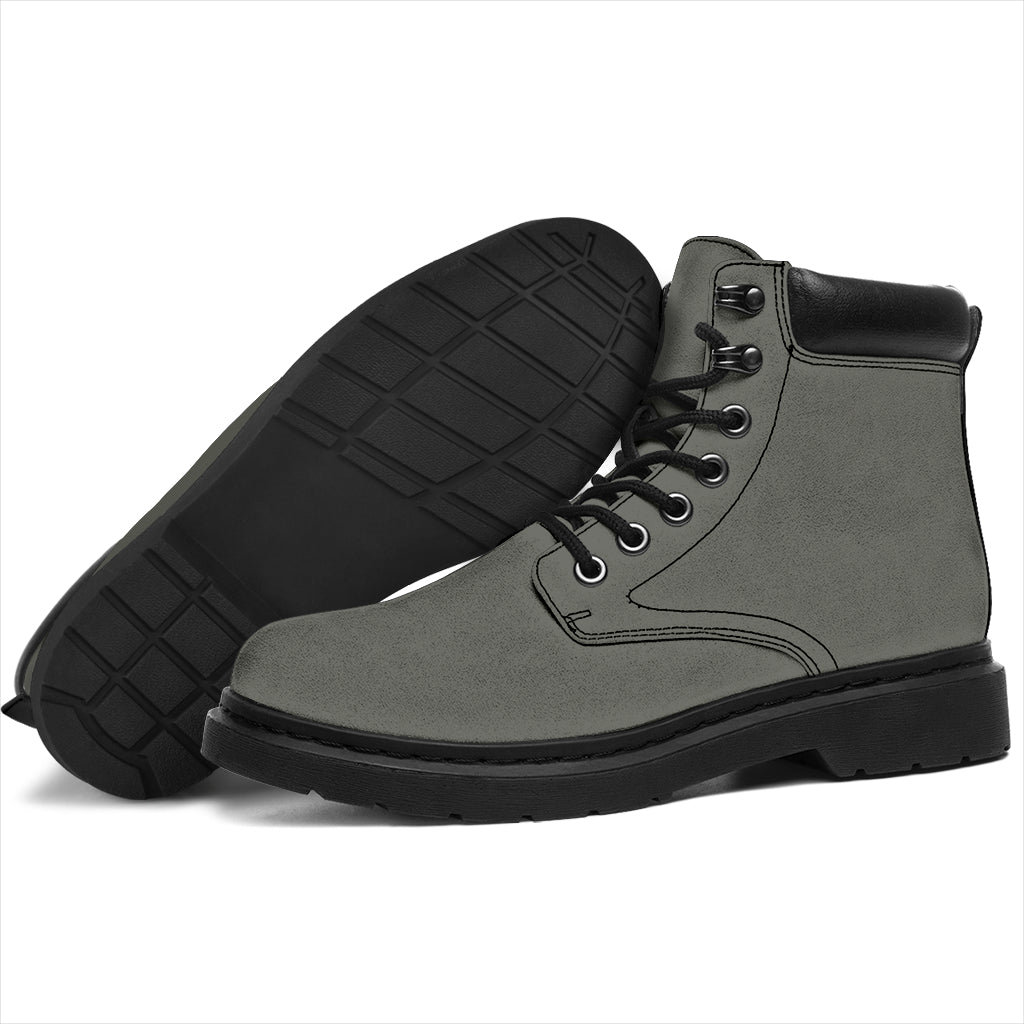 This is a microsuede pair of boots for men and women. It is a grey colour all over. The boot has a black sole black trim, black laces, and sits above the ankle. It is set on a white background.