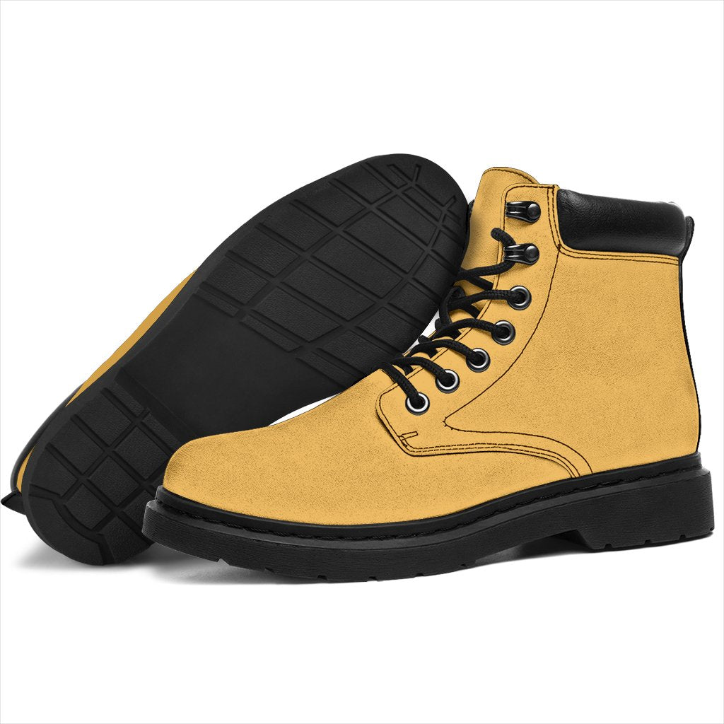 This is a microsuede pair of boots for men and women. It is a dark yellow colour all over. The boot has a black sole black trim, black laces, and sits above the ankle. It is set on a white background.