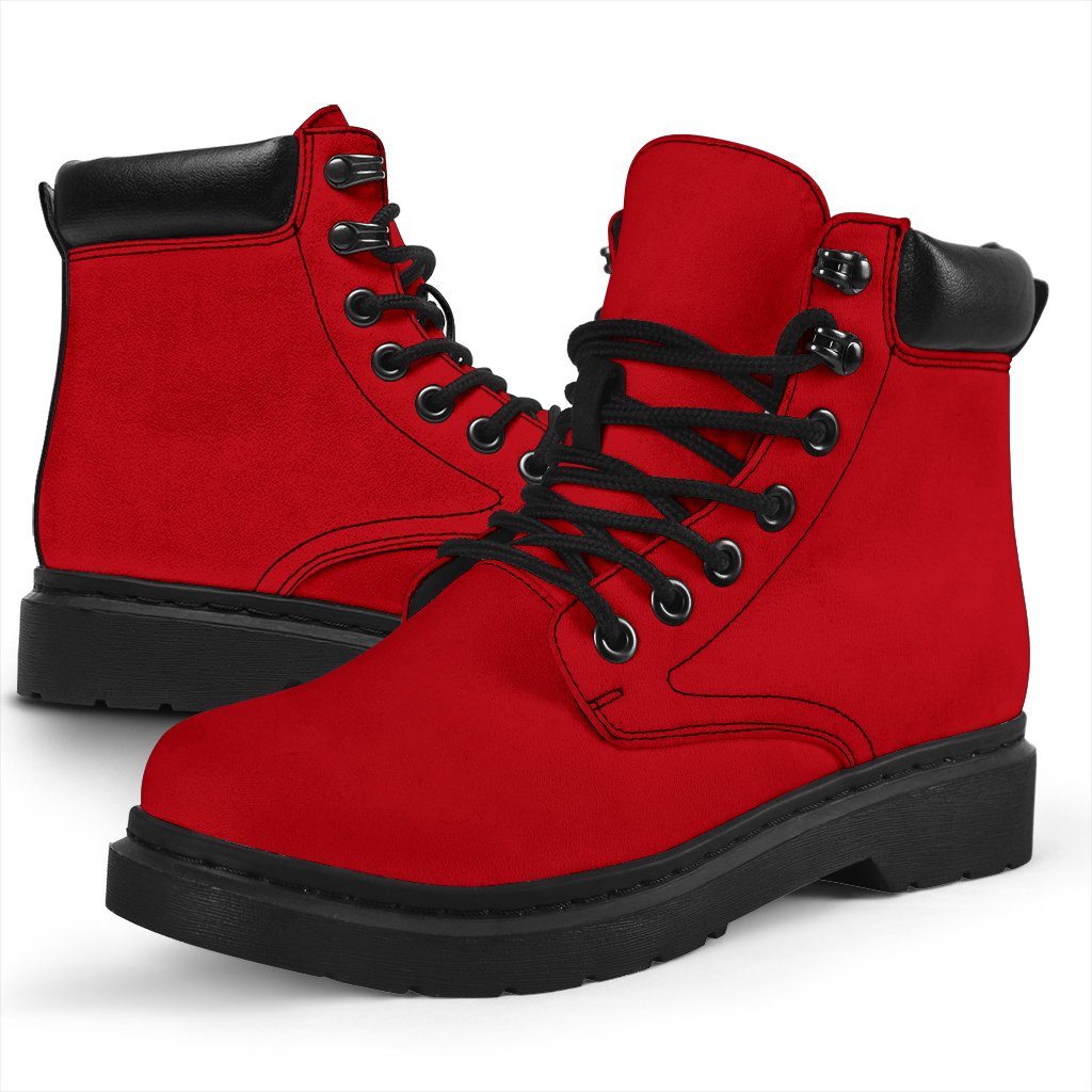 This is a microsuede pair of boots for men and women. It is a red colour all over. The boot has a black sole black trim, black laces, and sits above the ankle. It is set on a white background.