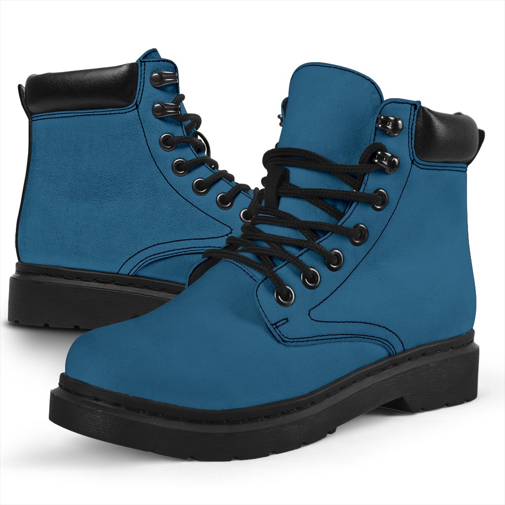 This is a microsuede pair of boots for men and women. It is a vintage sky colour all over. The boot has a black sole black trim, black laces, and sits above the ankle. It is set on a white background.