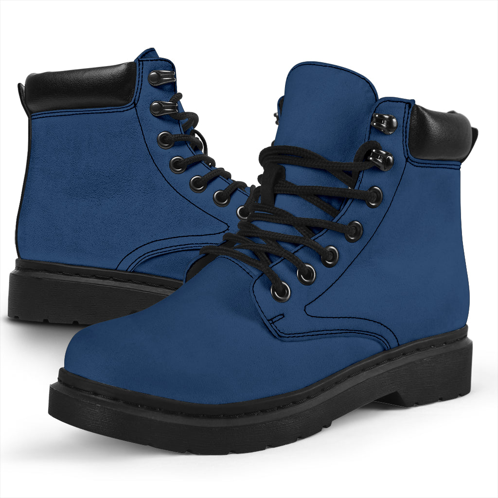 This is a microsuede pair of boots for men and women. It is a ink blue colour all over. The boot has a black sole black trim, black laces, and sits above the ankle. It is set on a white background.