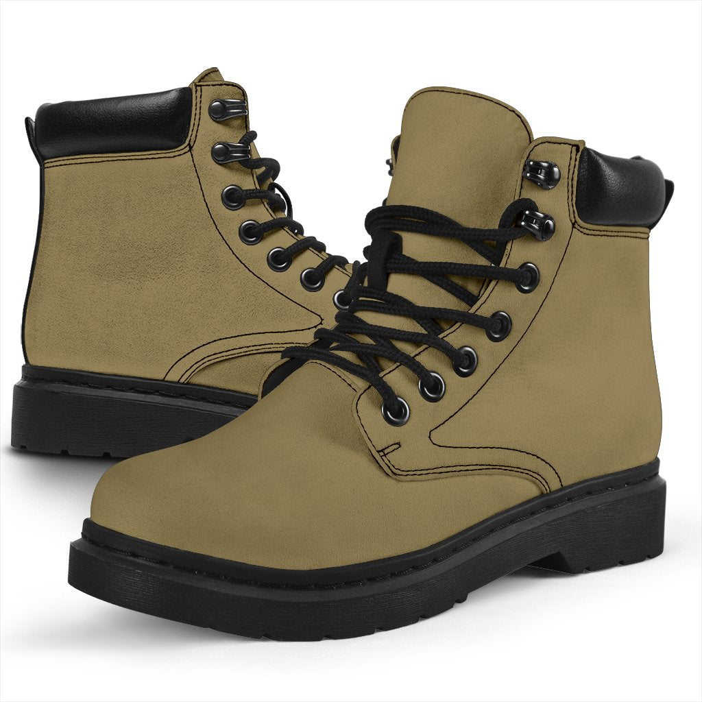 This is a microsuede pair of boots for men and women. It is a light khaki colour all over. The boot has a black sole black trim, black laces, and sits above the ankle. It is set on a white background.