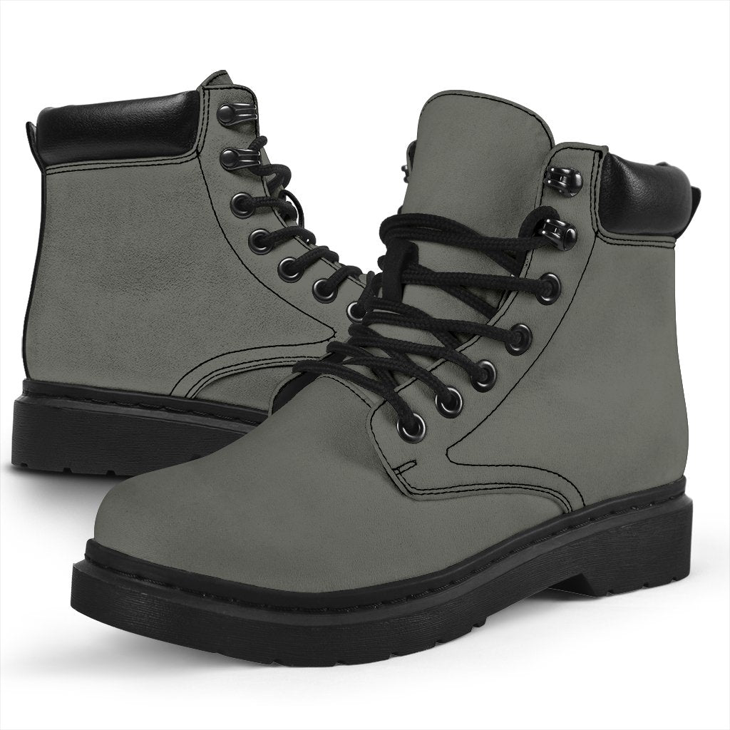 This is a microsuede pair of boots for men and women. It is a grey colour all over. The boot has a black sole black trim, black laces, and sits above the ankle. It is set on a white background.