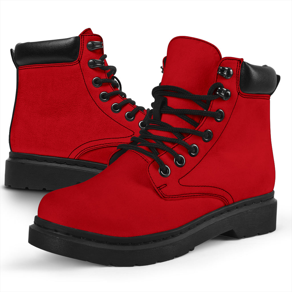 This is a microsuede pair of boots for men and women. It is a red colour all over. The boot has a black sole black trim, black laces, and sits above the ankle. It is set on a white background.