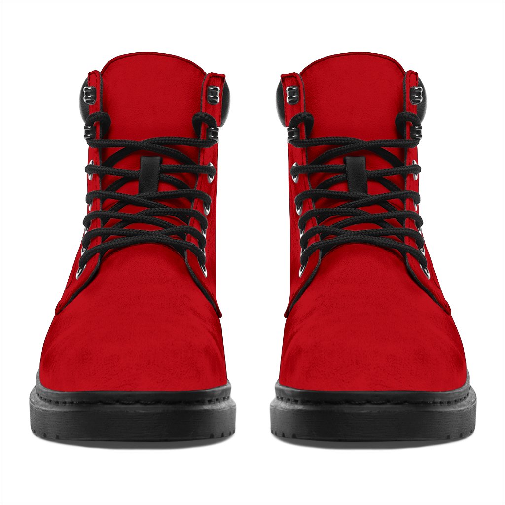 This is a microsuede pair of boots for men and women. It is a red colour all over. The boot has a black sole black trim, black laces, and sits above the ankle. It is set on a white background.