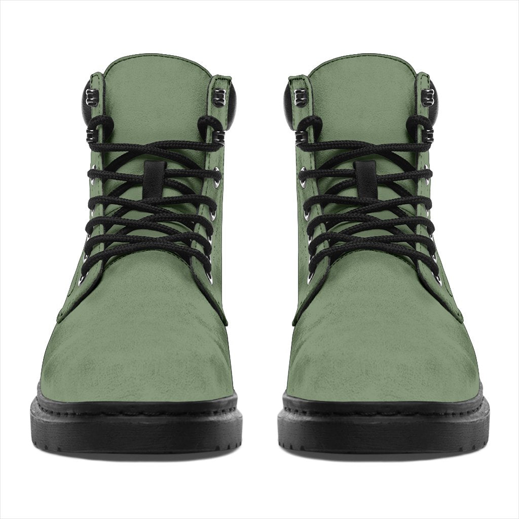 This is a microsuede pair of boots for men and women. It is a deep mint green colour all over. The boot has a black sole black trim, black laces, and sits above the ankle. It is set on a white background.