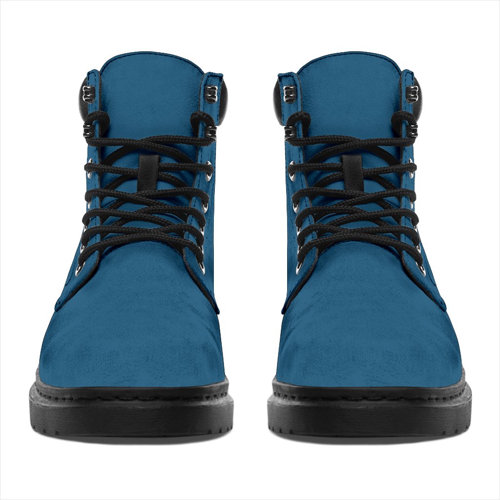 This is a microsuede pair of boots for men and women. It is a vintage sky colour all over. The boot has a black sole black trim, black laces, and sits above the ankle. It is set on a white background.