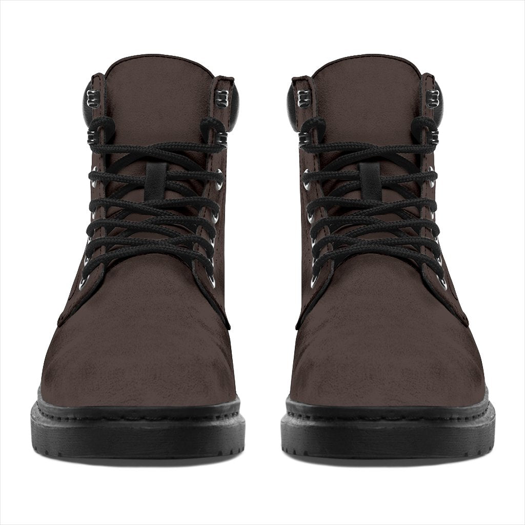 This is a microsuede pair of boots for men and women. It is a dark chocolate colour all over. The boot has a black sole black trim, black laces, and sits above the ankle. It is set on a white background.