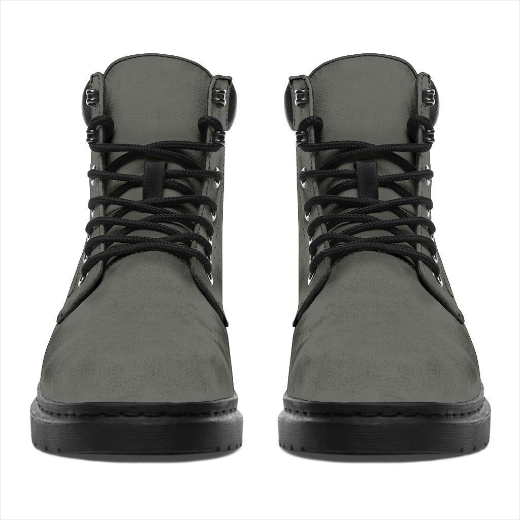 This is a microsuede pair of boots for men and women. It is a grey colour all over. The boot has a black sole black trim, black laces, and sits above the ankle. It is set on a white background.